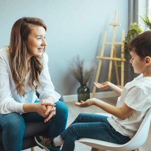 Child therapist talking with young boy during counseling session