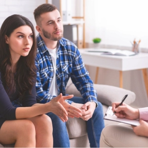 Couple discussing relationship issues with therapist during counseling session