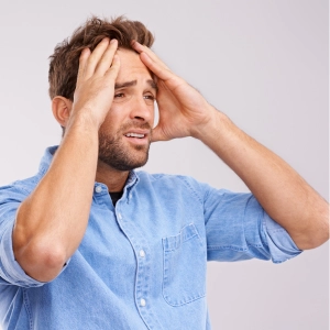 Man experiencing stress and anxiety holding his head