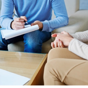 Therapist taking notes during counseling session with client
